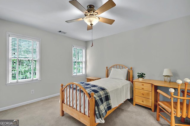 bedroom featuring baseboards, multiple windows, light colored carpet, and visible vents