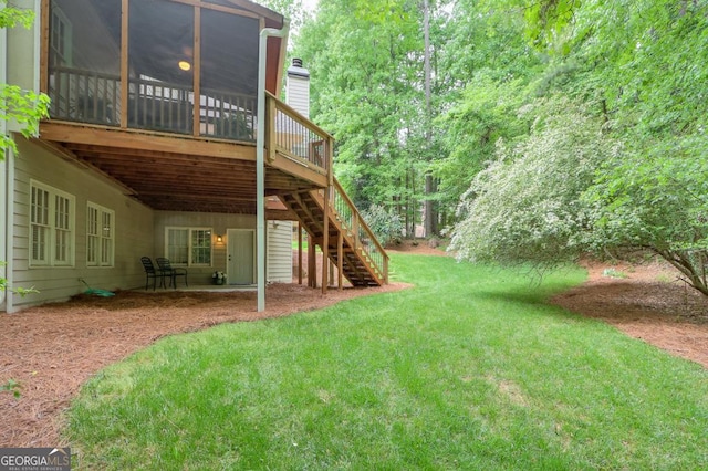 view of yard with stairway, a wooden deck, and a sunroom