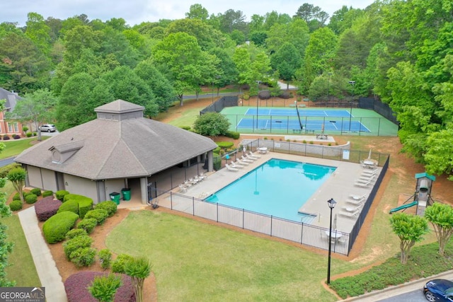 pool featuring a tennis court and fence