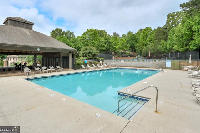 community pool featuring a patio area and fence