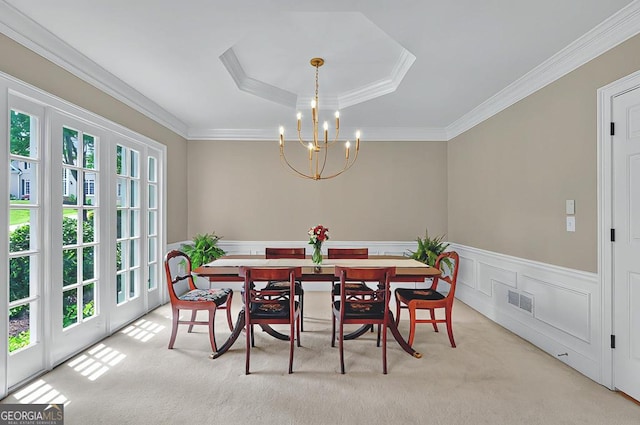 dining room with visible vents, a wainscoted wall, an inviting chandelier, ornamental molding, and carpet
