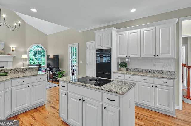 kitchen featuring light wood-style floors, decorative backsplash, black appliances, and white cabinets