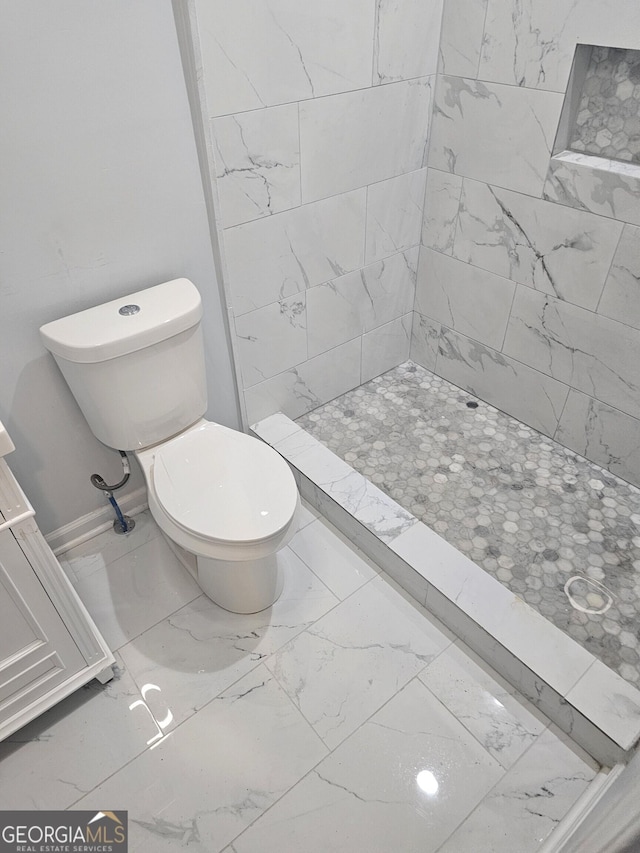 full bathroom featuring toilet, a shower stall, and marble finish floor