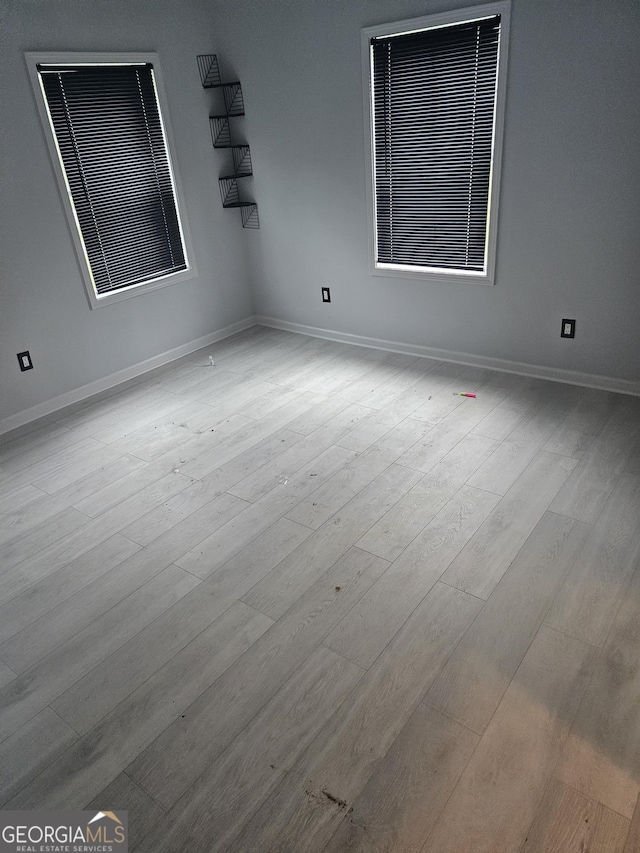 empty room featuring baseboards and wood finished floors