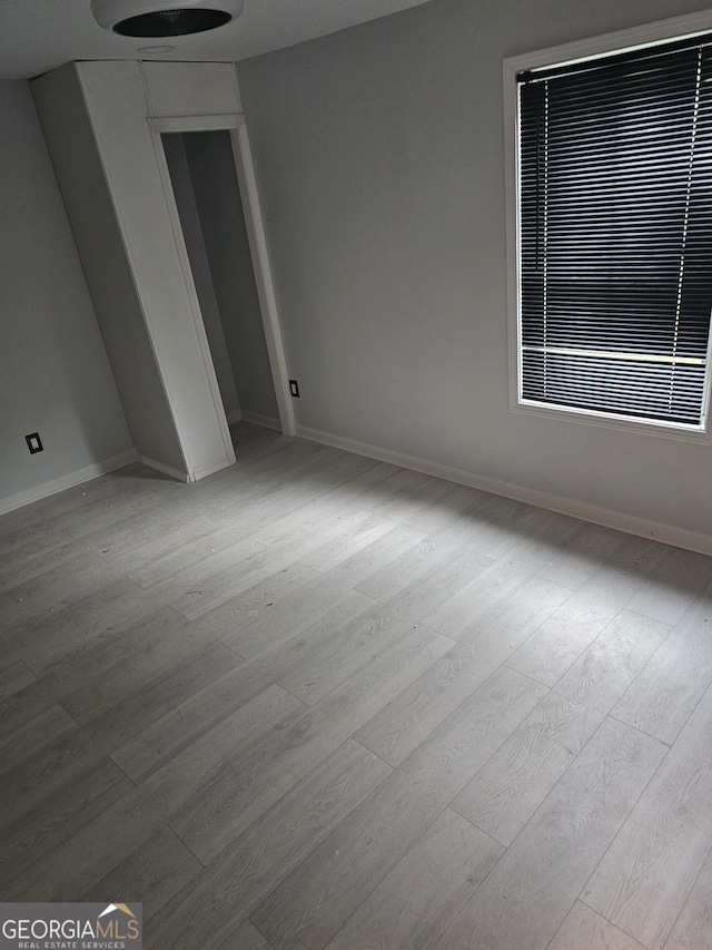unfurnished room featuring baseboards and wood finished floors