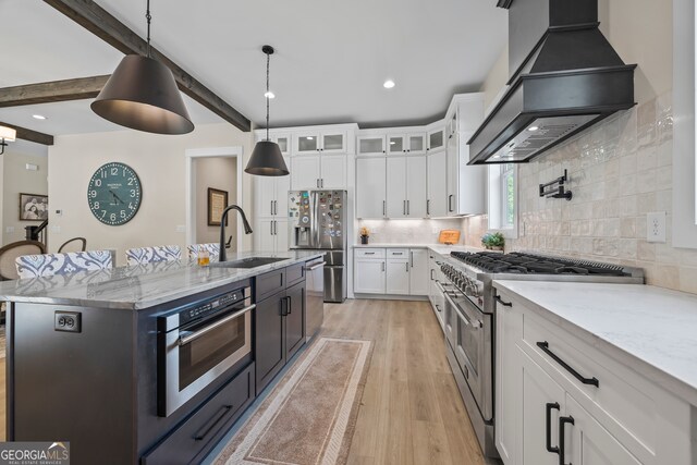 kitchen featuring a sink, white cabinetry, custom exhaust hood, and stainless steel appliances
