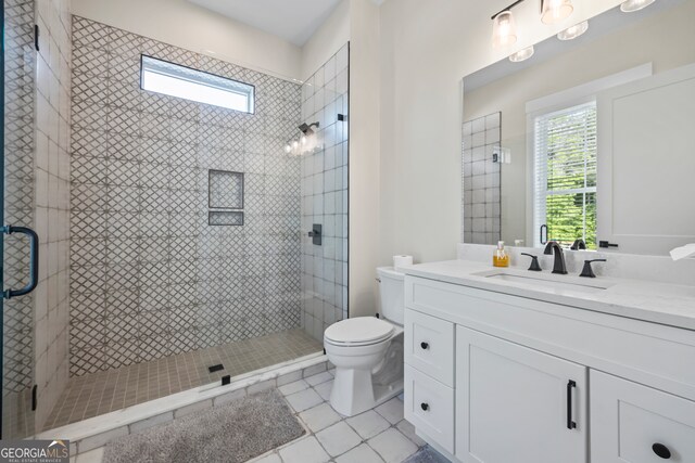 full bathroom featuring vanity, tile patterned floors, a stall shower, and toilet