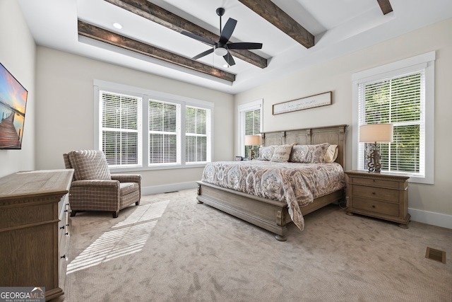 bedroom with baseboards, multiple windows, beam ceiling, and light colored carpet