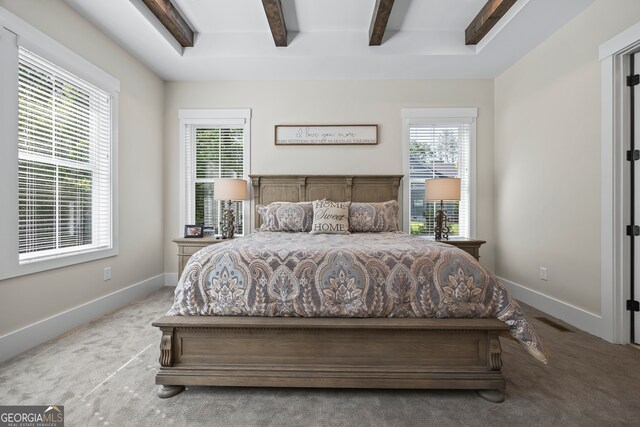 bedroom with multiple windows, carpet flooring, and beam ceiling