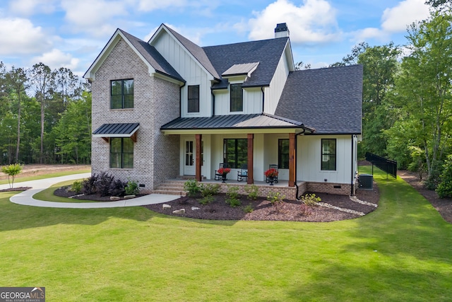 view of front of house featuring board and batten siding, covered porch, a standing seam roof, a front yard, and roof with shingles