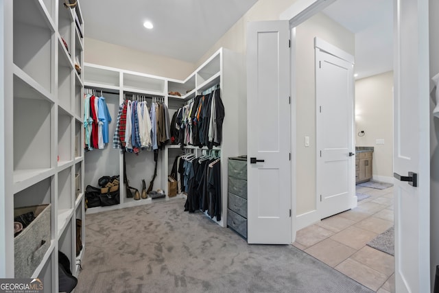 walk in closet featuring carpet floors and tile patterned floors
