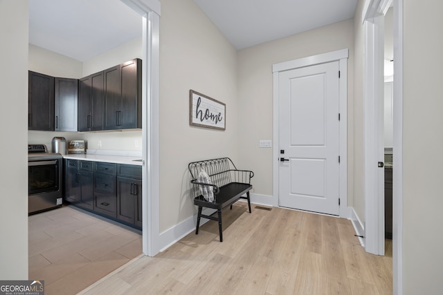 interior space with washer / clothes dryer, baseboards, visible vents, and light wood-type flooring