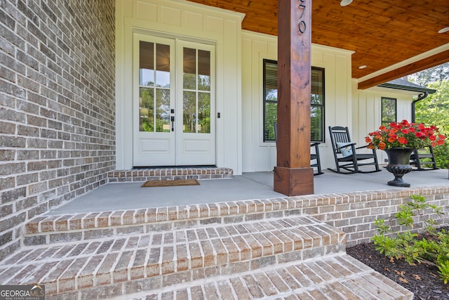 entrance to property with french doors, board and batten siding, and covered porch