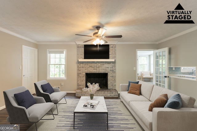 2814 Brackenwood Dr, Snellville, GA 30039 - living area with ceiling fan, wood finished floors, crown molding, a fireplace, and a textured ceiling