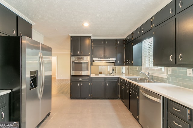 2814 Brackenwood Dr, Snellville, GA 30039 - kitchen with appliances with stainless steel finishes, under cabinet range hood, light countertops, crown molding, and decorative backsplash