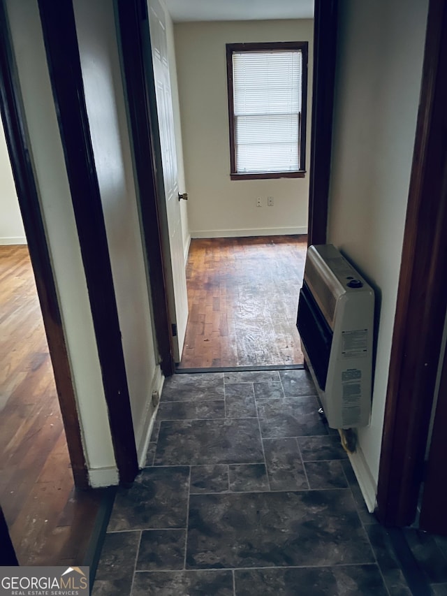 hall with baseboards and heating unit