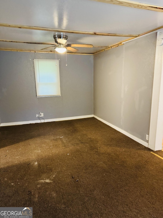 empty room with carpet flooring, a ceiling fan, and baseboards