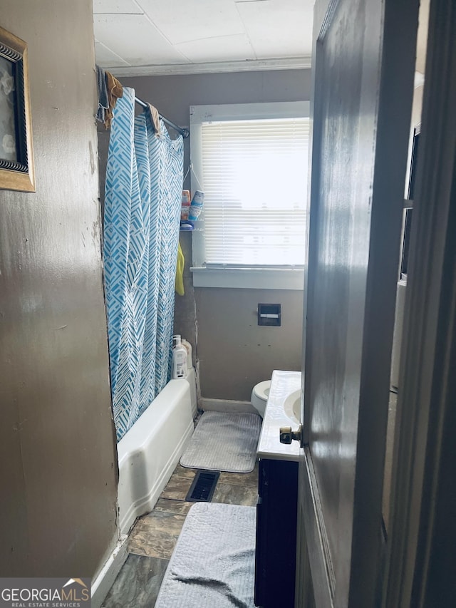 full bathroom with vanity, baseboards, toilet, and shower / tub combo