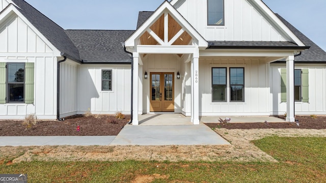 exterior space featuring board and batten siding, french doors, a shingled roof, and a front lawn
