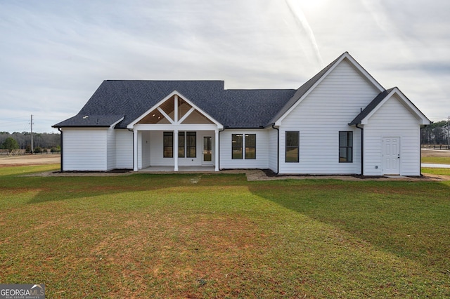 view of front of property with roof with shingles and a front yard