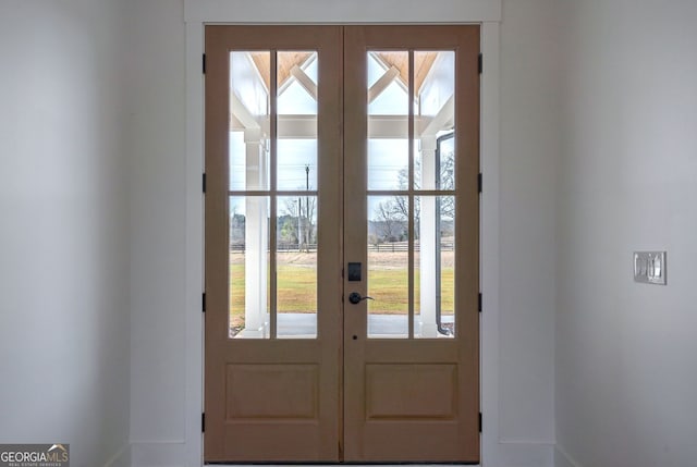 doorway to outside featuring baseboards and french doors