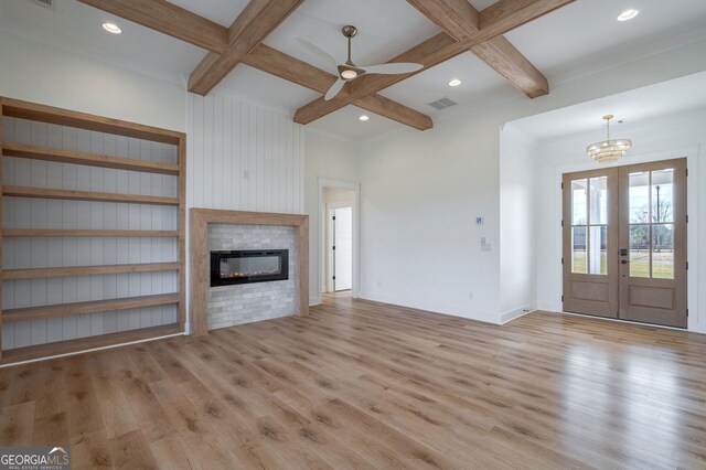 unfurnished living room featuring beamed ceiling, visible vents, a glass covered fireplace, and wood finished floors
