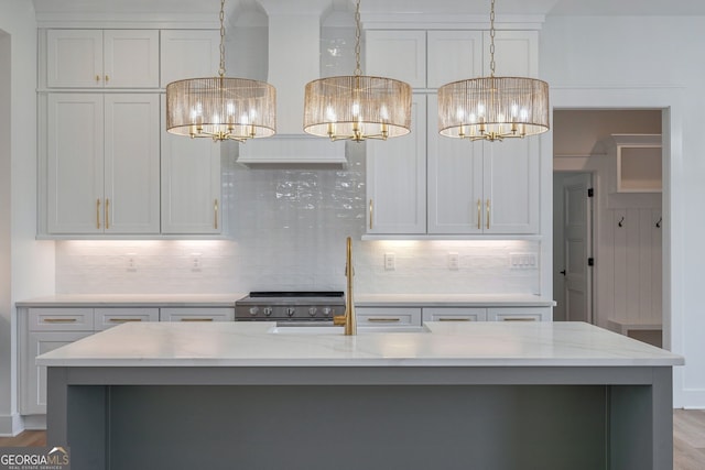 kitchen featuring pendant lighting, stainless steel range, a notable chandelier, and tasteful backsplash