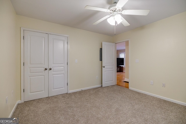 unfurnished bedroom with a ceiling fan, baseboards, carpet, and a closet