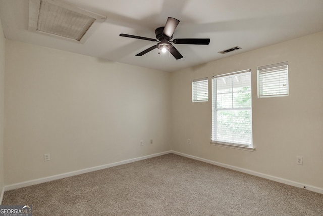 empty room featuring carpet flooring, baseboards, visible vents, and attic access