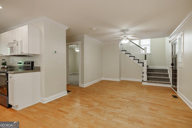 unfurnished living room featuring ceiling fan, visible vents, light wood-type flooring, stairway, and baseboards