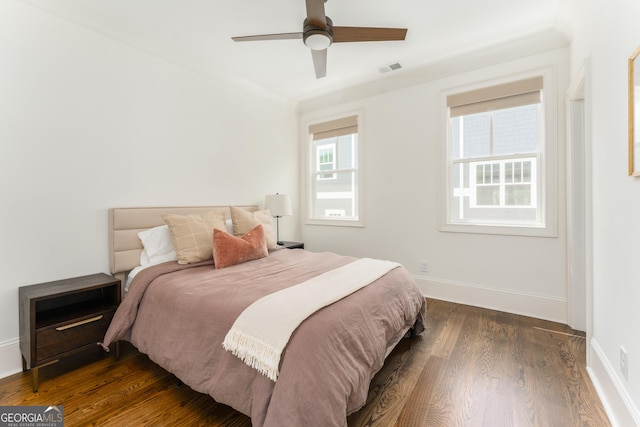 bedroom with dark wood-type flooring, a ceiling fan, baseboards, and visible vents