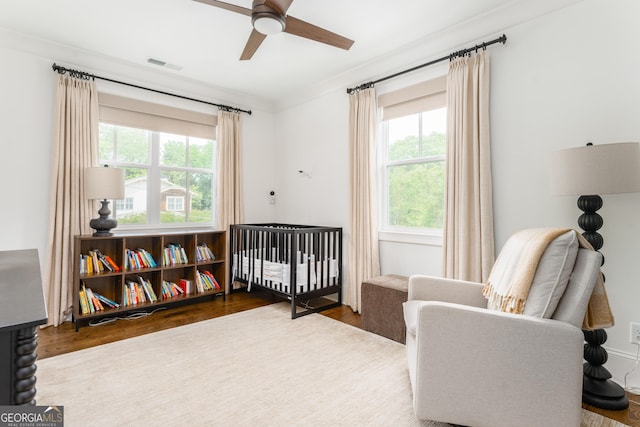 bedroom featuring visible vents, ceiling fan, wood finished floors, and multiple windows