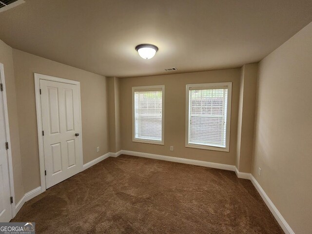 10856 Ellicot Way, Alpharetta, GA 30022 - unfurnished bedroom featuring dark carpet and baseboards