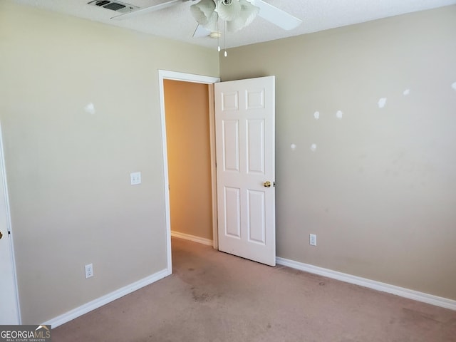 unfurnished bedroom with visible vents, a ceiling fan, baseboards, and light carpet