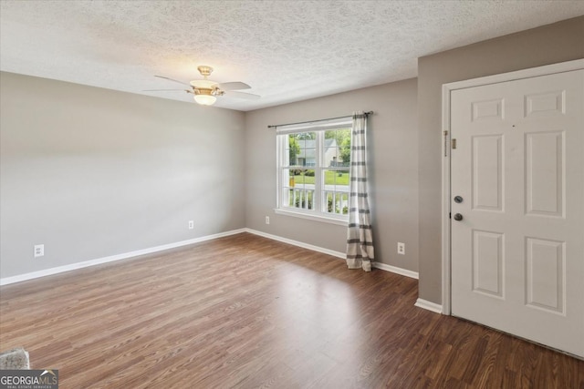 interior space featuring a textured ceiling, baseboards, ceiling fan, and wood finished floors