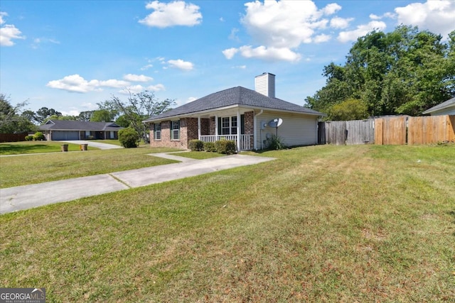 view of front of property featuring a porch, a chimney, brick siding, fence, and a front lawn