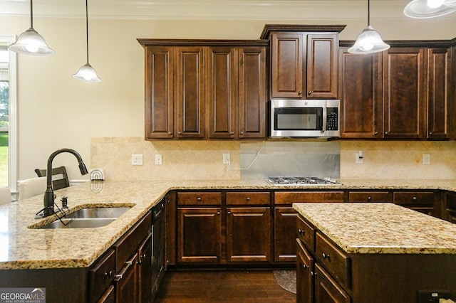 kitchen with light stone counters, a sink, stainless steel appliances, a peninsula, and ornamental molding