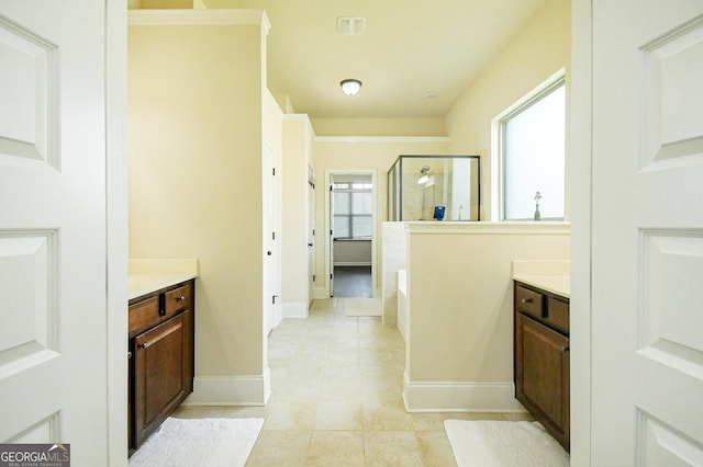 full bathroom featuring vanity, baseboards, a shower stall, and tile patterned floors