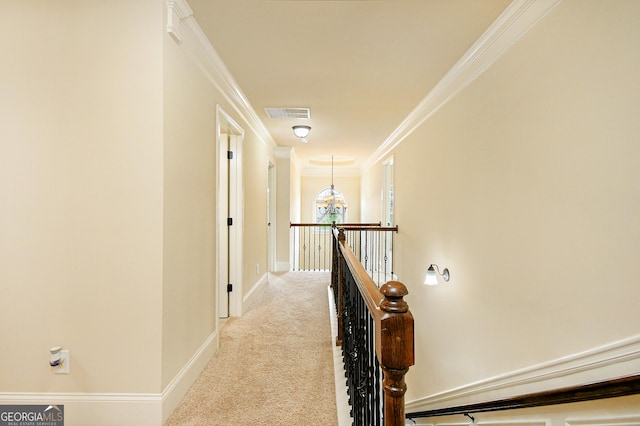 hall featuring crown molding, an upstairs landing, carpet floors, baseboards, and a notable chandelier