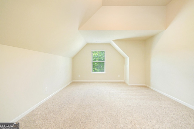 bonus room with baseboards, light carpet, and vaulted ceiling