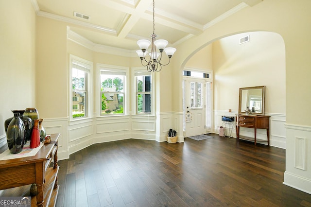foyer entrance with dark wood-style flooring, a chandelier, arched walkways, and visible vents