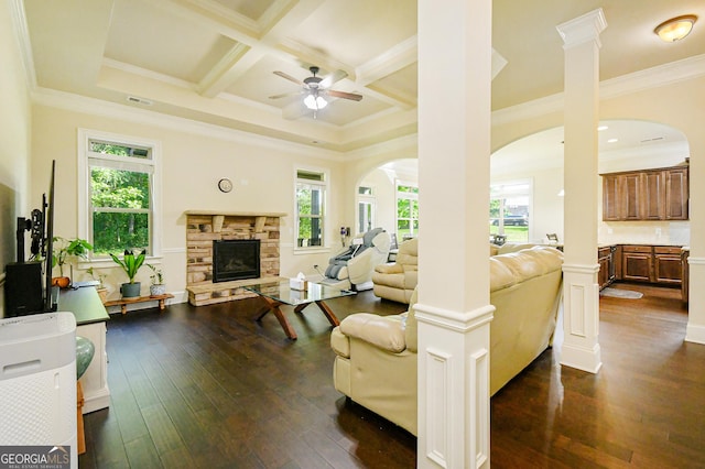 living room with arched walkways, dark wood-style flooring, ceiling fan, and a fireplace