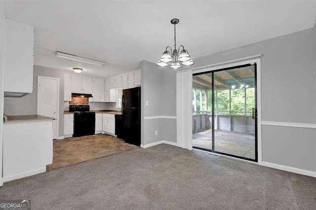 3929 Emerald Springs Ct, Decatur, GA 30035 - kitchen with carpet flooring, white cabinets, a chandelier, under cabinet range hood, and black appliances