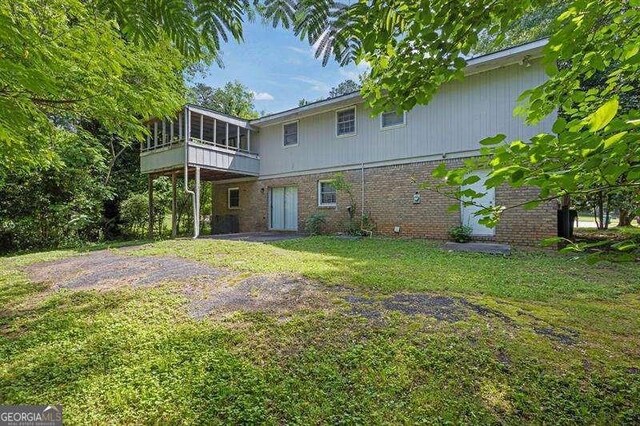3929 Emerald Springs Ct, Decatur, GA 30035 - rear view of house with a yard, brick siding, and a sunroom