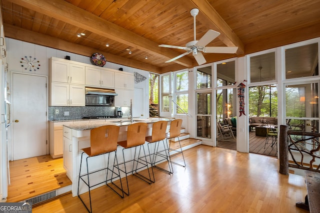 1006 Perrin Cove Rd, Tiger, GA 30576 - kitchen with a wood ceiling with exposed beams, light wood finished floors, ceiling fan, tasteful backsplash, and white cabinets
