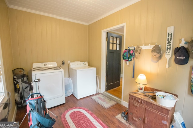 washroom with laundry area, ornamental molding, radiator, wood finished floors, and washing machine and dryer