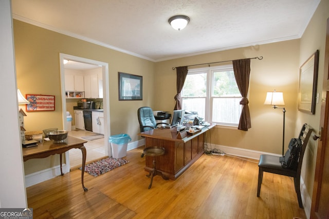 office area with light wood-style floors, baseboards, and ornamental molding