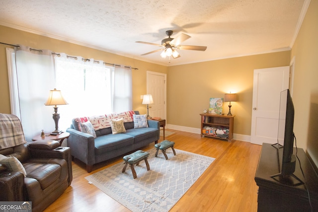living area featuring a textured ceiling, ceiling fan, ornamental molding, and light wood-style floors