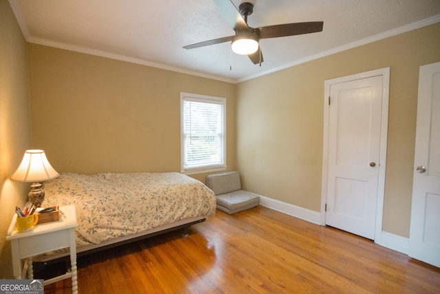 bedroom featuring baseboards, ornamental molding, a ceiling fan, and wood finished floors