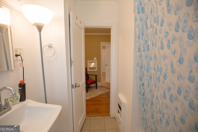 full bath featuring a sink, a shower with curtain, tile patterned flooring, and crown molding